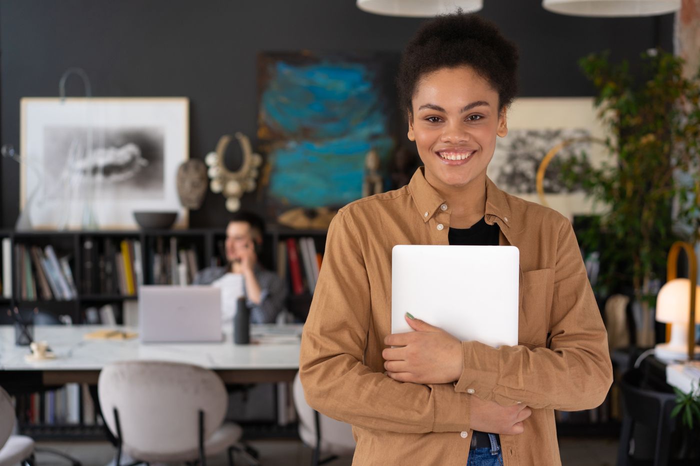 Independent professional holding a laptop in a creative office